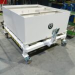 Contenedor autobasculante blanco con ruedas y logo de Útiles y Galvanotecnia