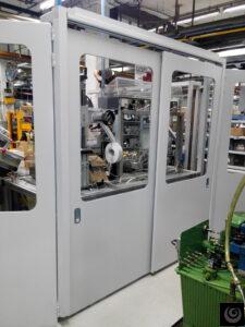 Cerramiento acústico industrial con puertas automáticas y ventanas de inspección